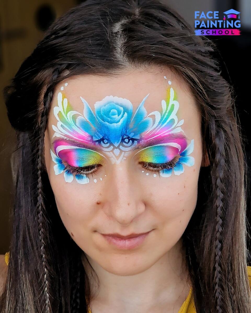 a girl looking down while wearing a fairy face paint design
