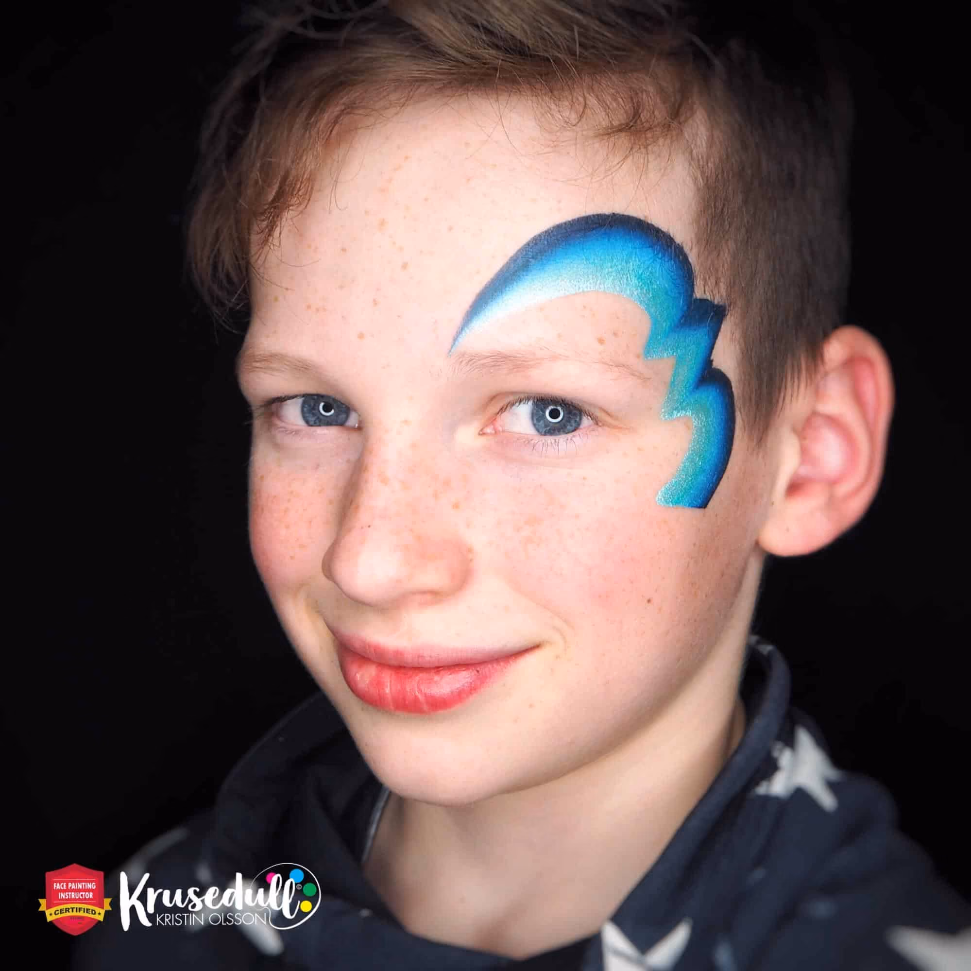 a boy with blue lines painted around his left eye