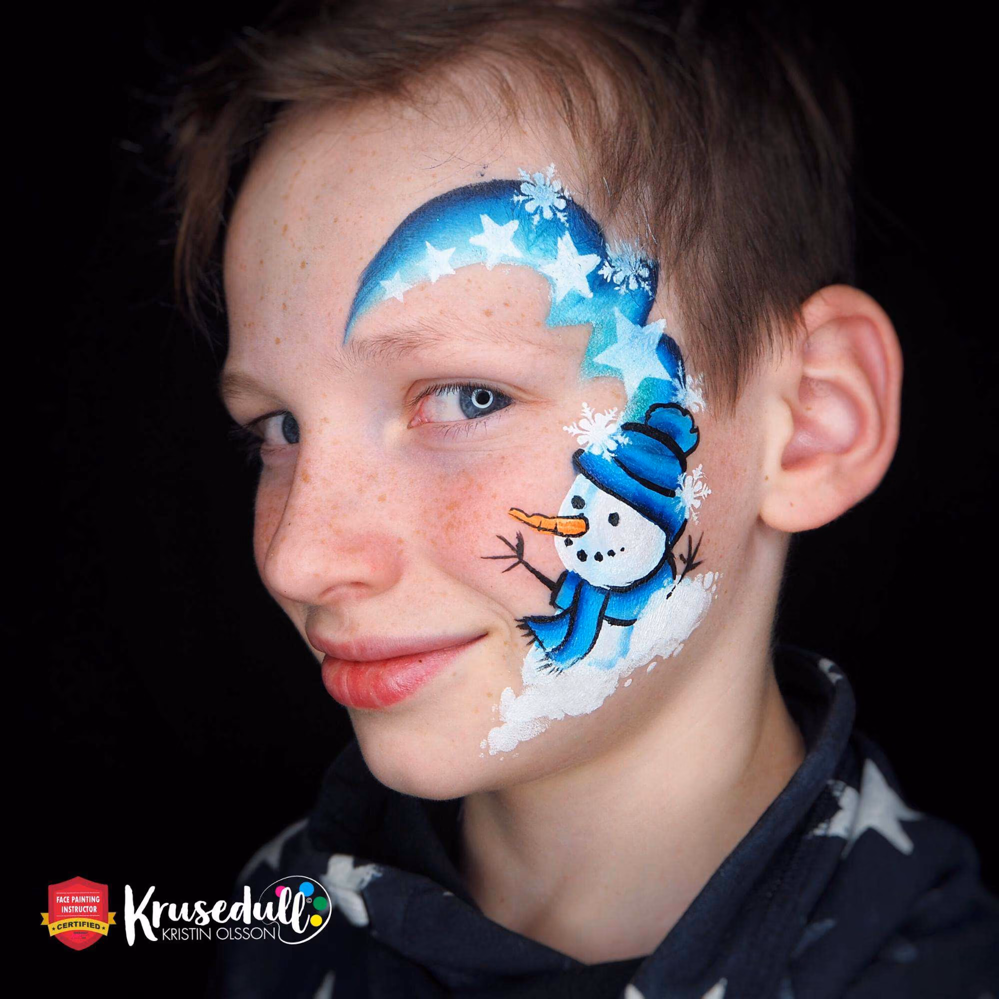a boy with a completed snowman face paint design