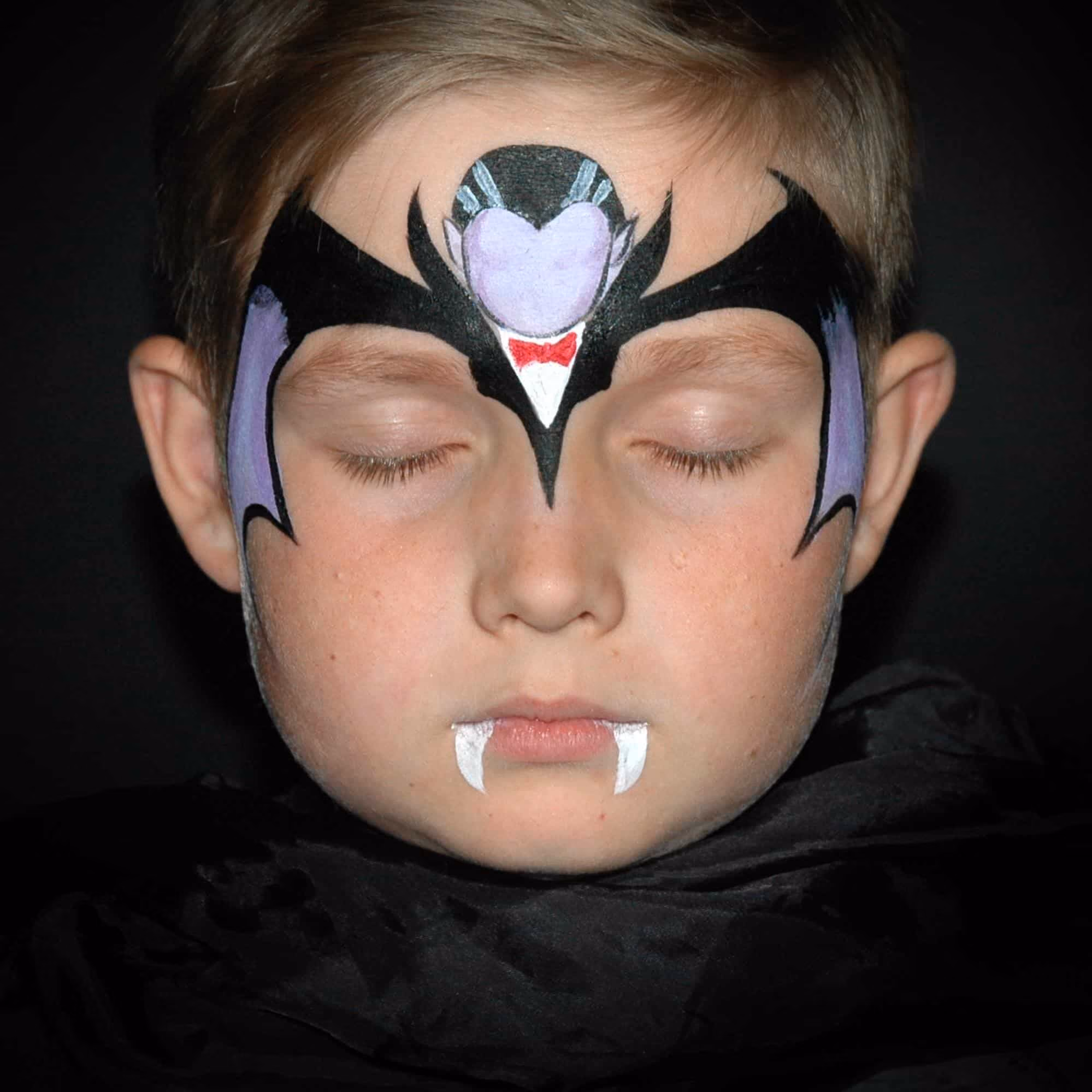 a child with hard outlined contures of a vampire fape paint on his forehead