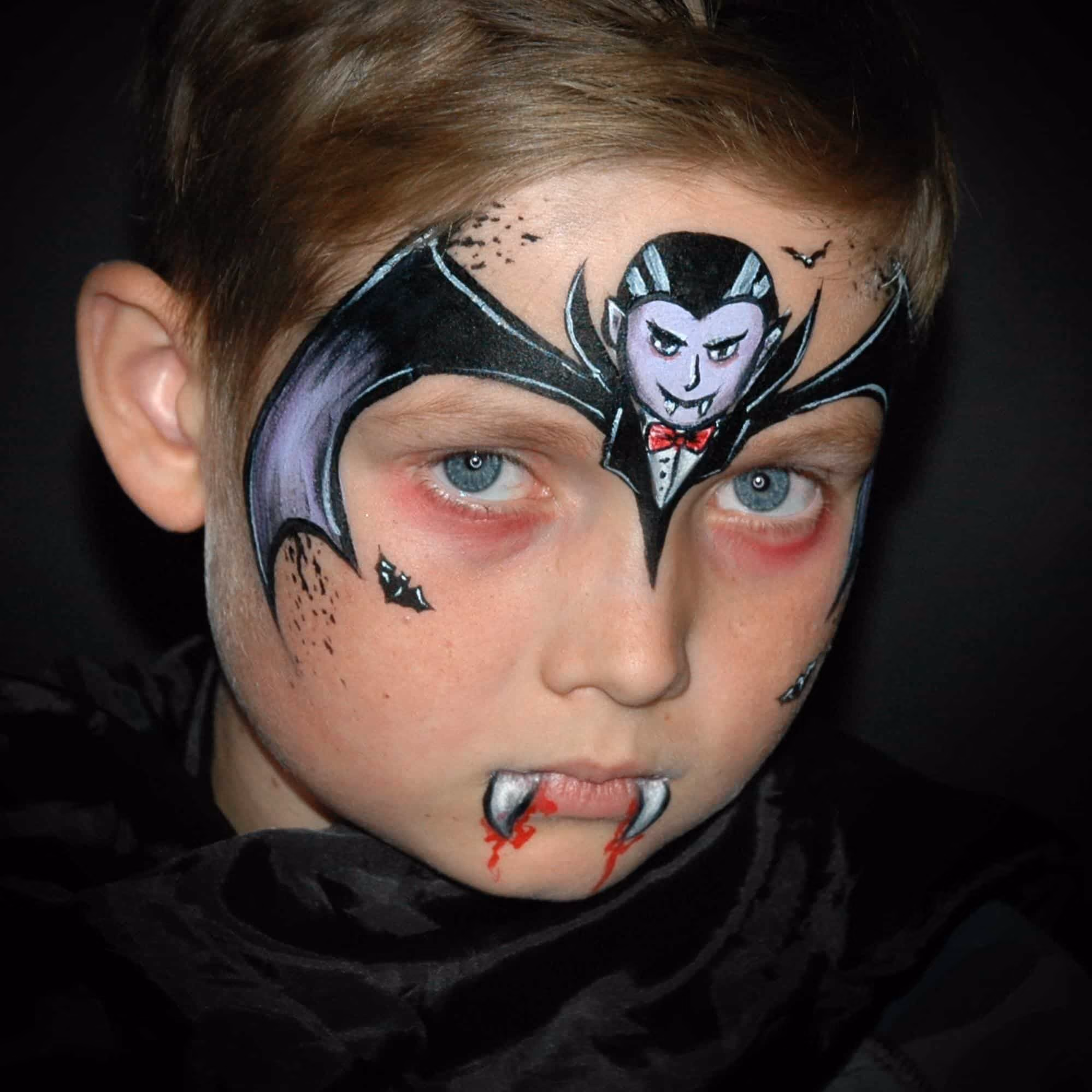 boy with a compleated vampire face paint on his forehead and mouth