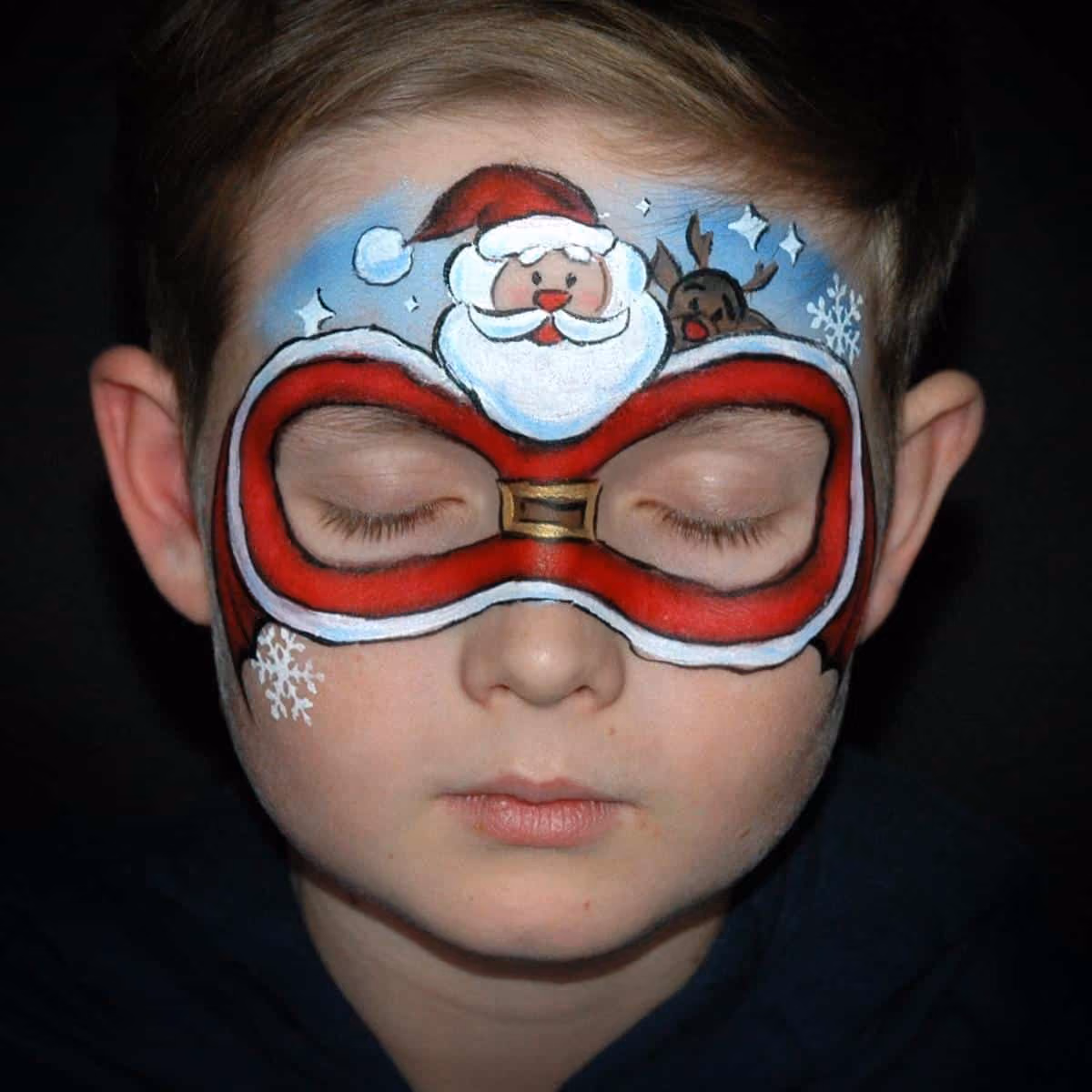 a boy with a compleated santa clause face painting design