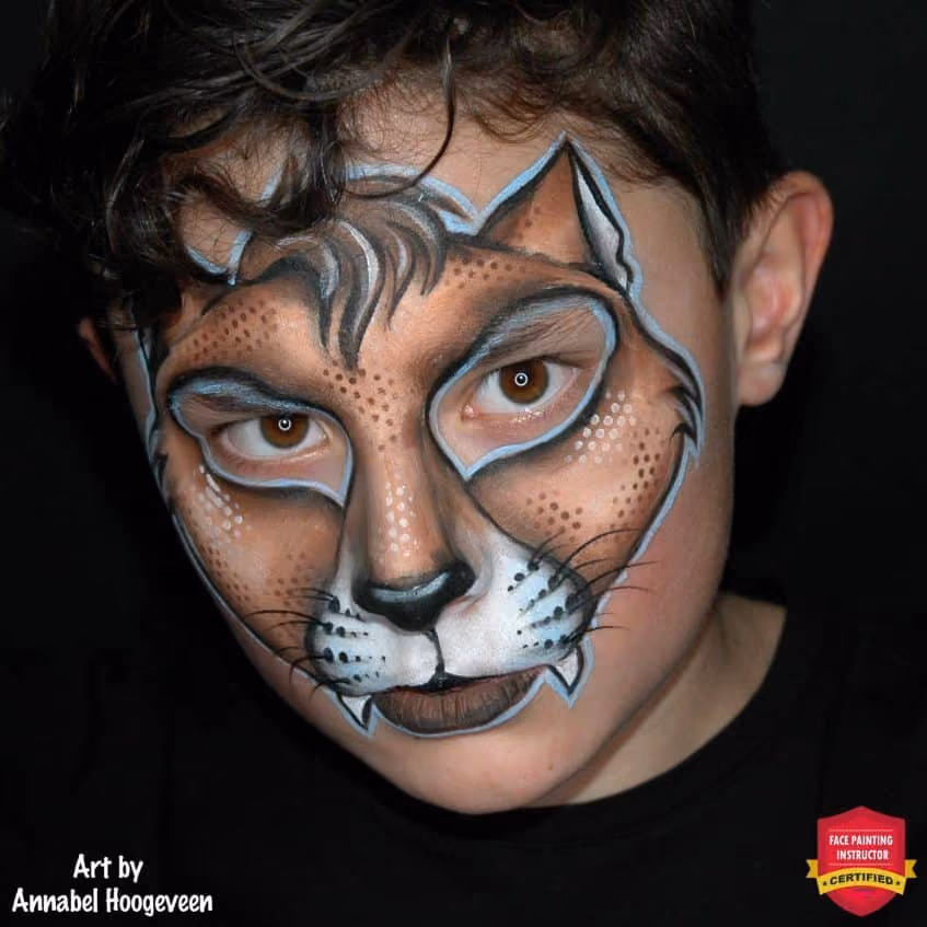 a boy looking at the camera with his halloween cat face paint design