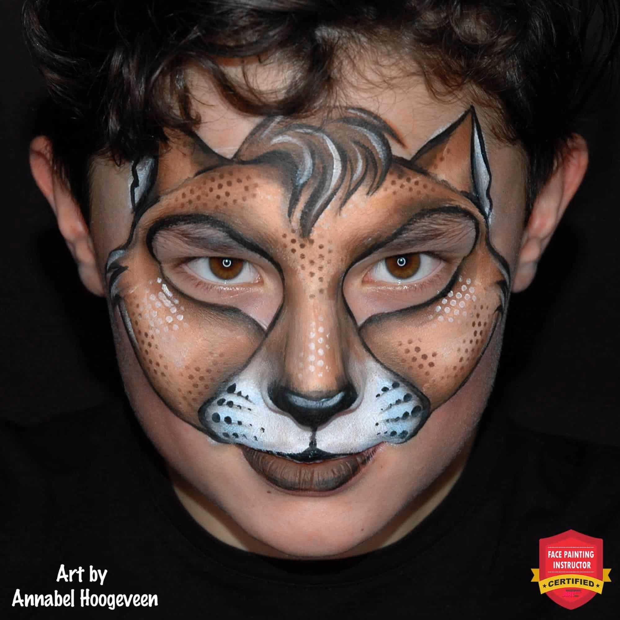 a boy looking at the camera with an compleated halloween cat face painting