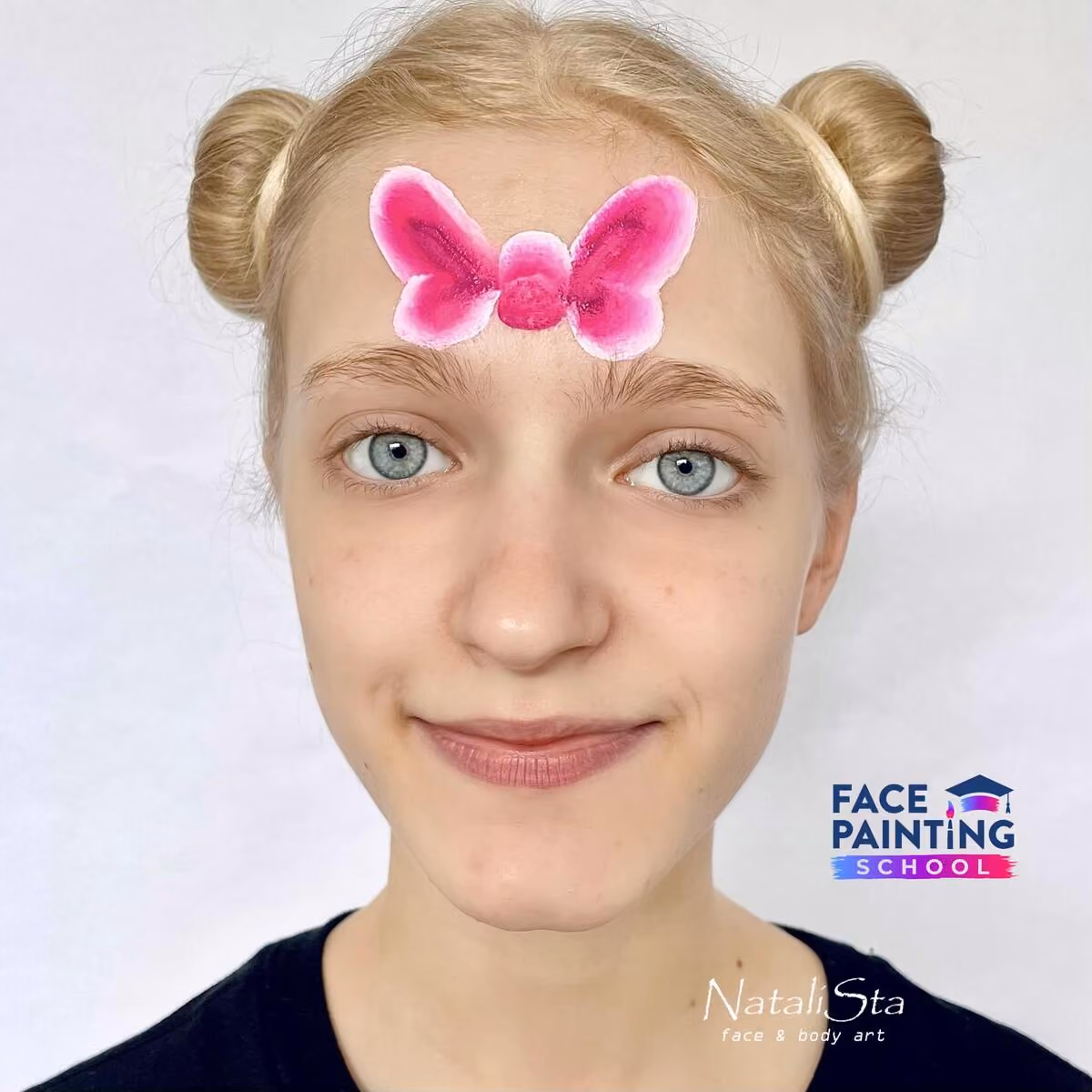 a girl with a pink bow painted on her face