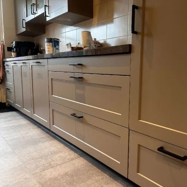 A kitchen with white cabinets and a counter top.