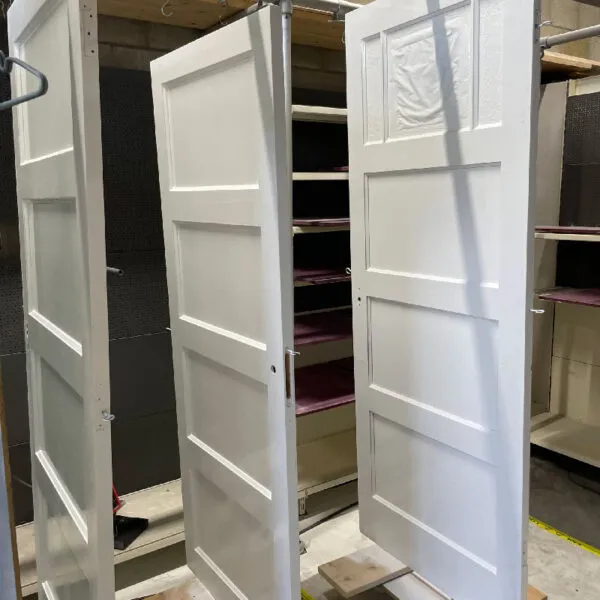 A couple of white doors sitting inside of a room.