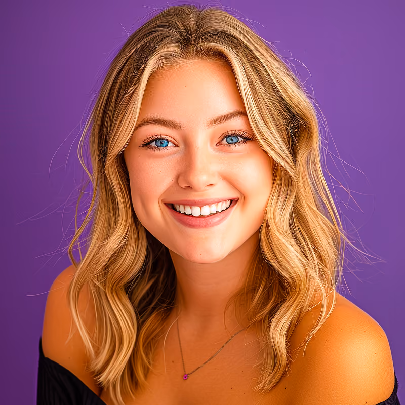 Smiling young woman with wavy blonde hair and blue eyes against a purple background.