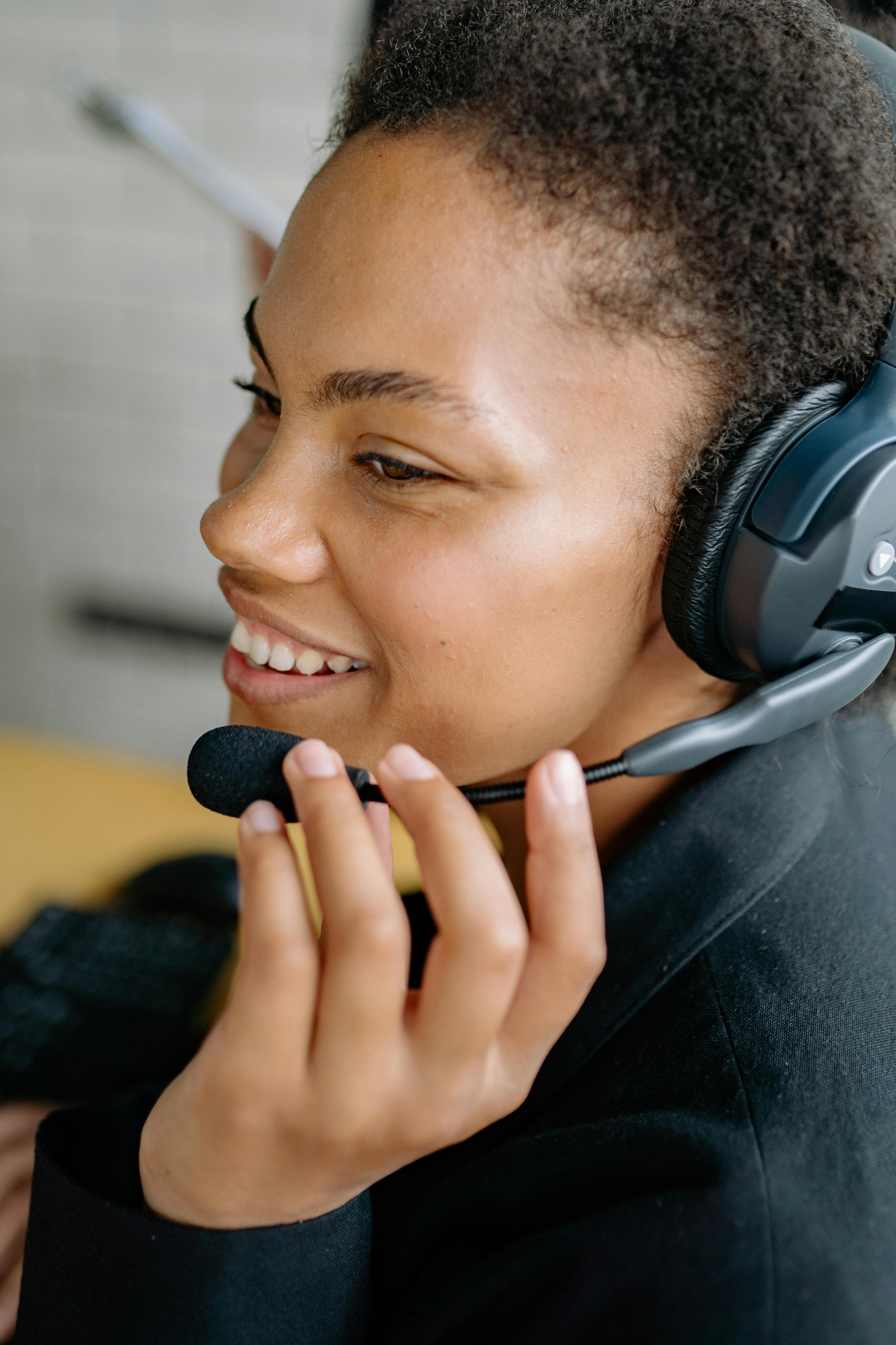 Smiling woman wearing headset with microphone in a professional setting.