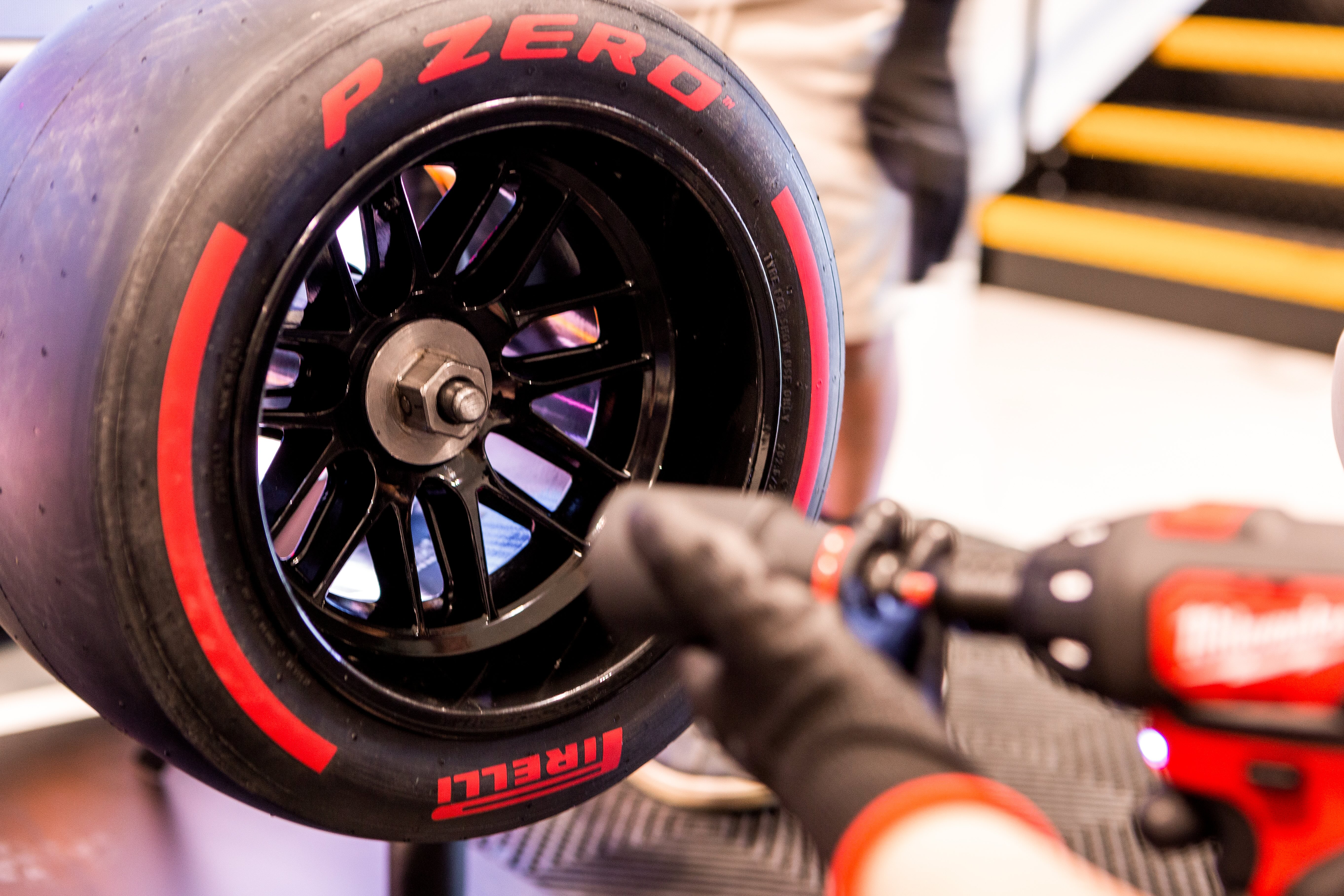 Close-up of Pirelli P Zero racing tire being handled during a pit stop.