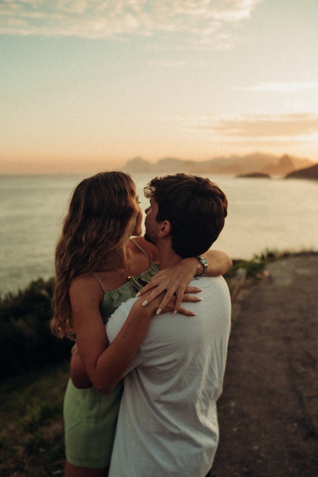 Couple s'embrassant devant un magnifique coucher de soleil sur la mer.