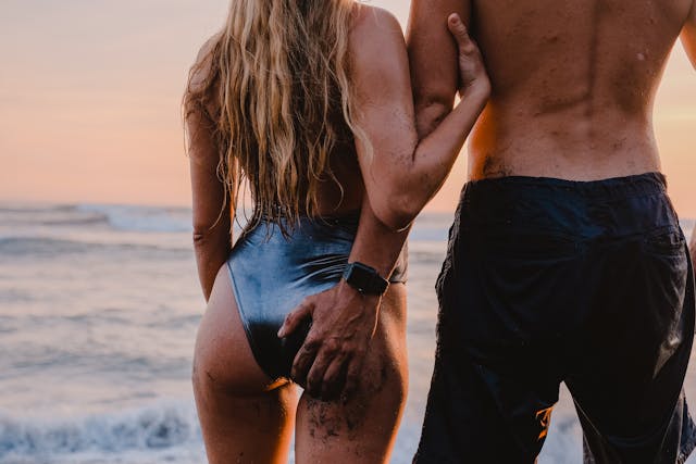 Couple main dans la main sur une plage au coucher du soleil, ambiance intime