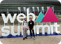 A picture of two men standing in front of a large Web Summit sign