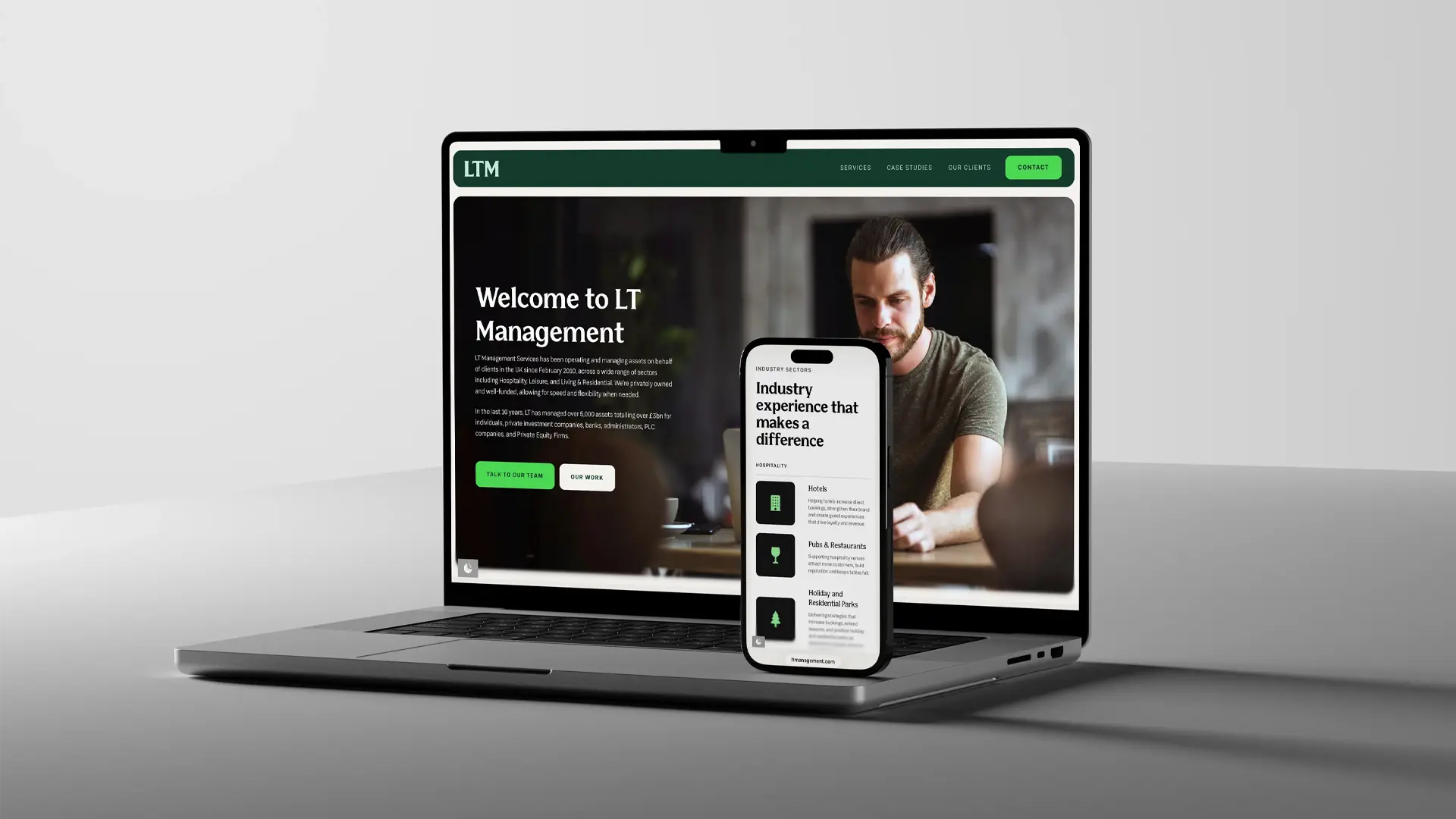 Open laptop displaying LT Management website homepage with a photo of a man working and text welcoming to LT Management, alongside a smartphone showing industry experience and sectors served including hotels, pubs, restaurants, and holiday parks.