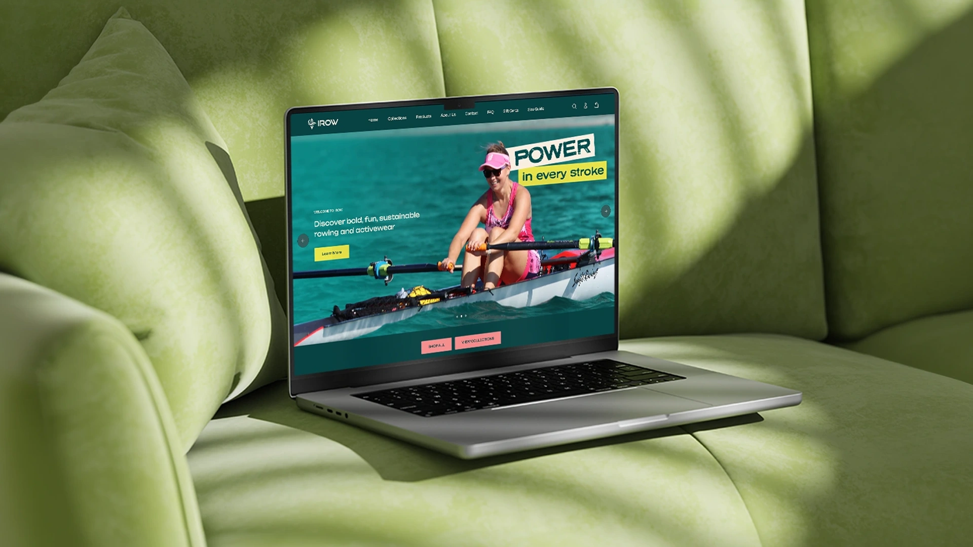Laptop resting on a light green cushioned sofa with the screen showing a website featuring a woman rowing on turquoise water, wearing a pink outfit and visor, with text reading 'POWER in every stroke' and 'Discover bold, fun, sustainable rowing and activewear'.