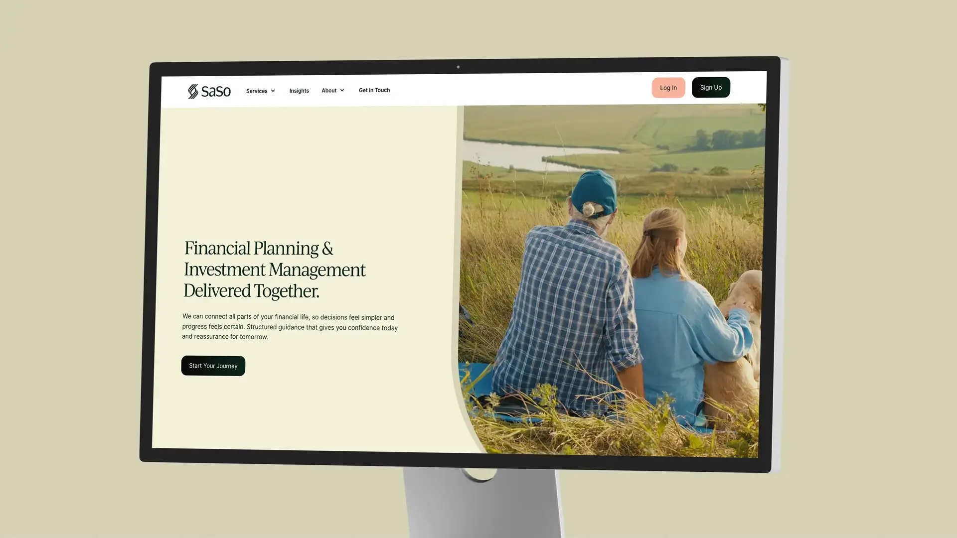 Website homepage on a computer screen showing a financial planning and investment management service with text emphasizing connection and confidence, alongside an image of two people sitting outdoors in a grassy field with a dog.