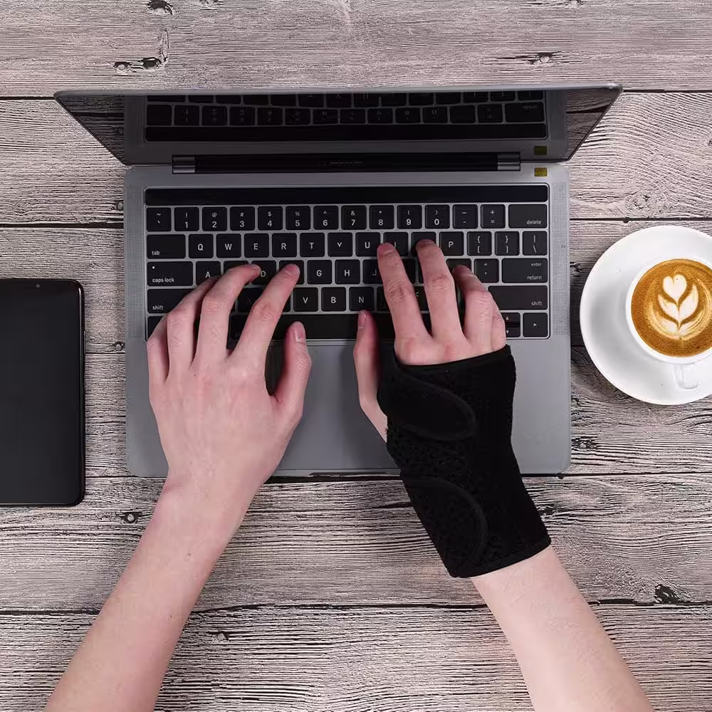 Woman at UK desk wearing elbow brace