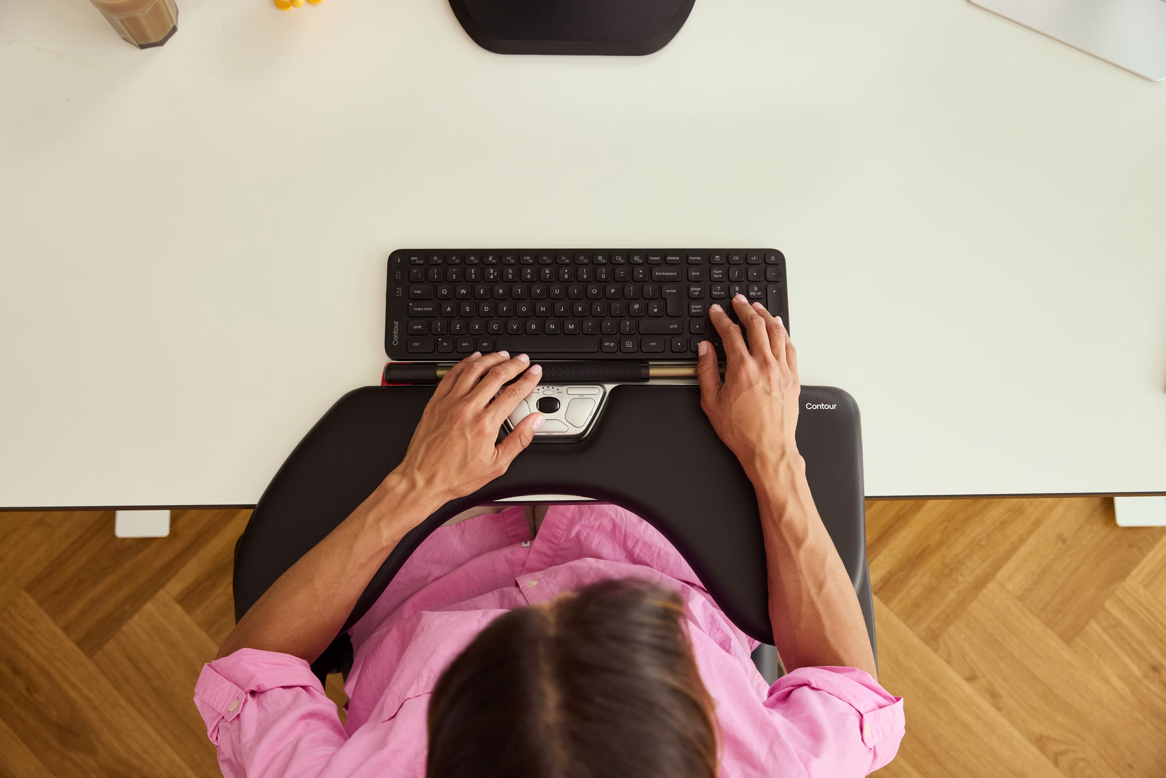 Worker using a centered rollermouse to keep wrists neutral and reduce ulnar strain.
