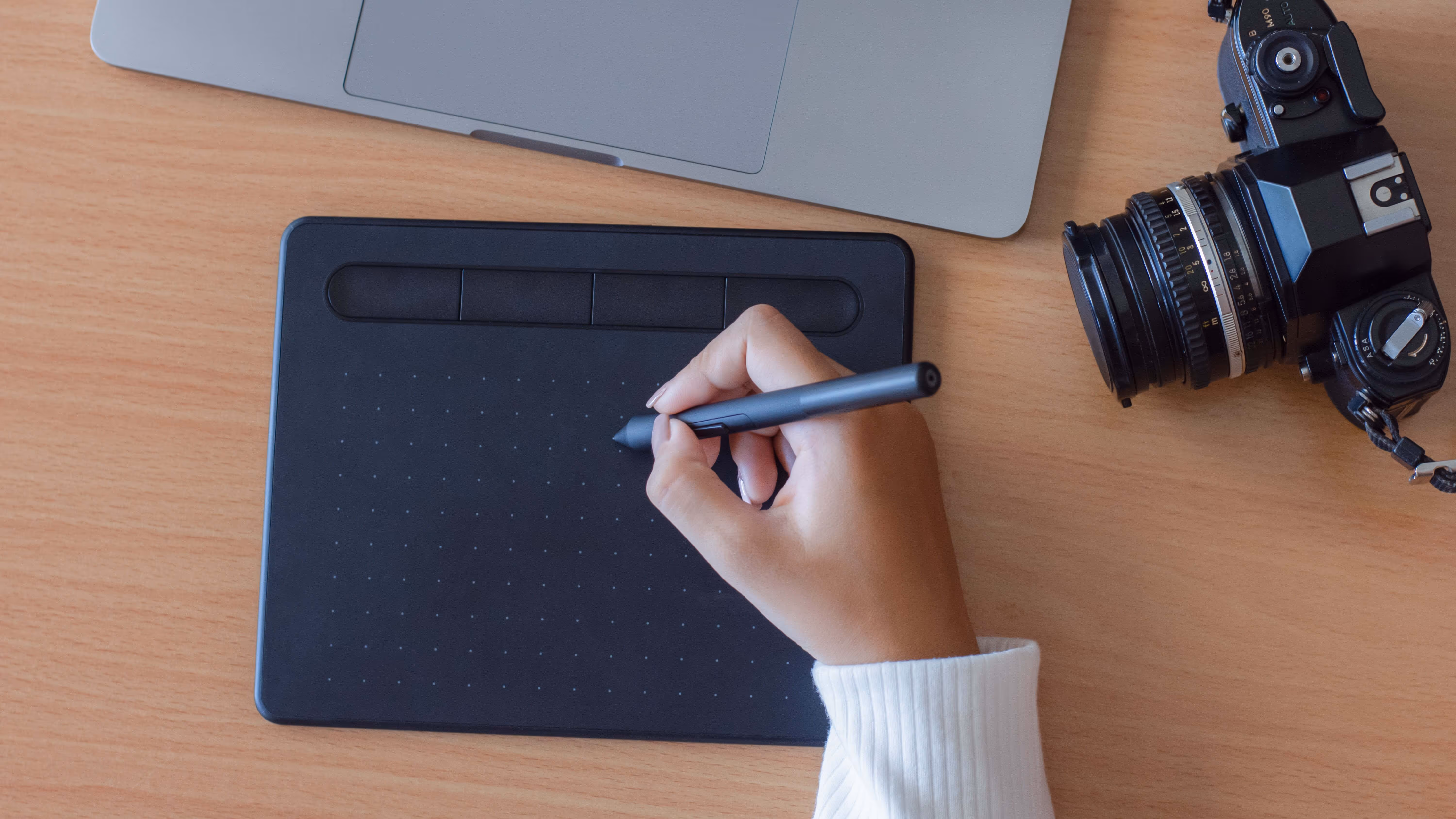 Close-up of a relaxed stylus grip with neutral wrist on supported forearm.