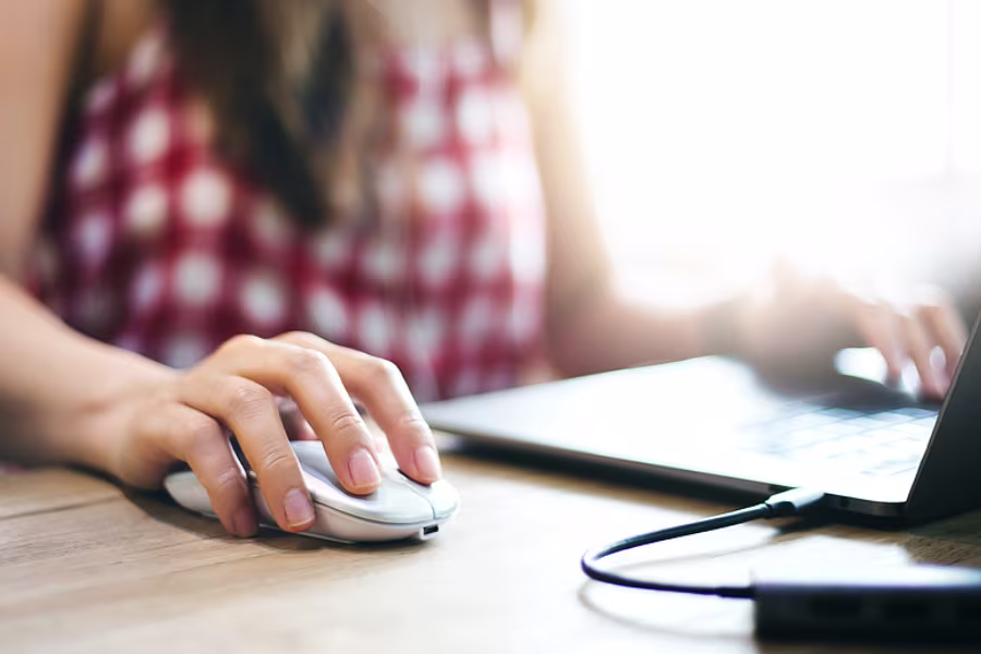 Close-up view of a woman using a traditional mouse