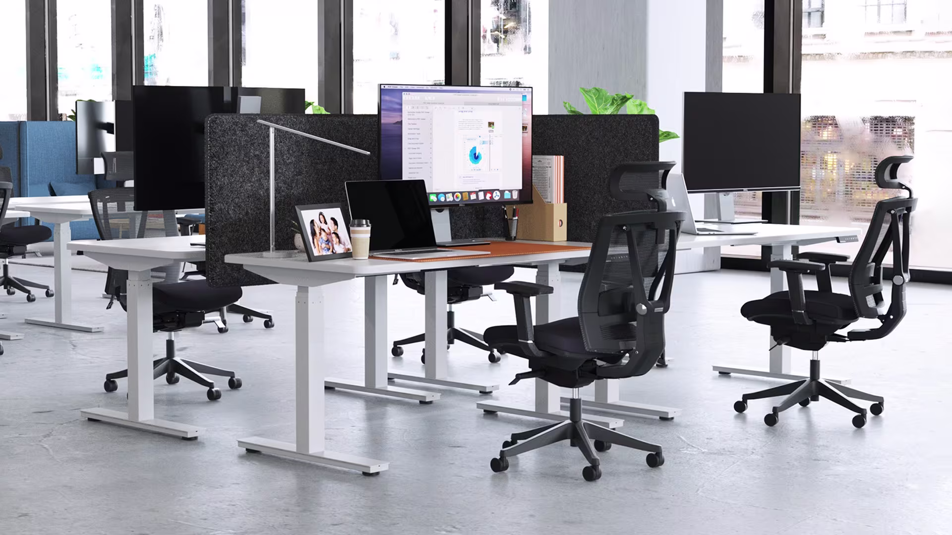 Modern office workspace with multiple ergonomic workstations featuring standing desks, ergonomic chairs, and acoustic privacy panels, demonstrating a complete ergonomic setup that supports healthy posture alongside an ergonomic mouse.