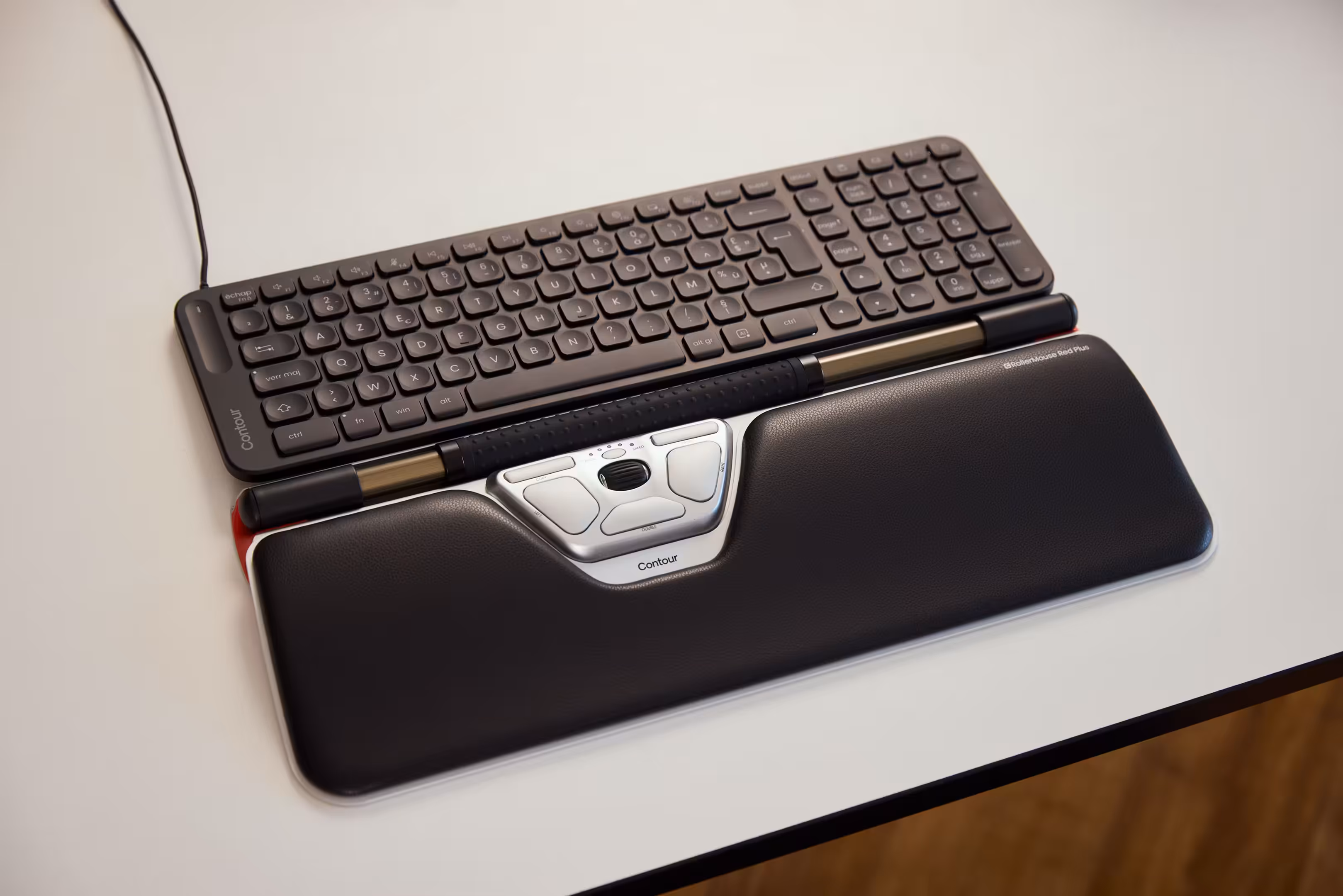 Contour Design RollerMouse Red Plus positioned in front of a keyboard, offering a central pointing device designed to reduce wrist strain.