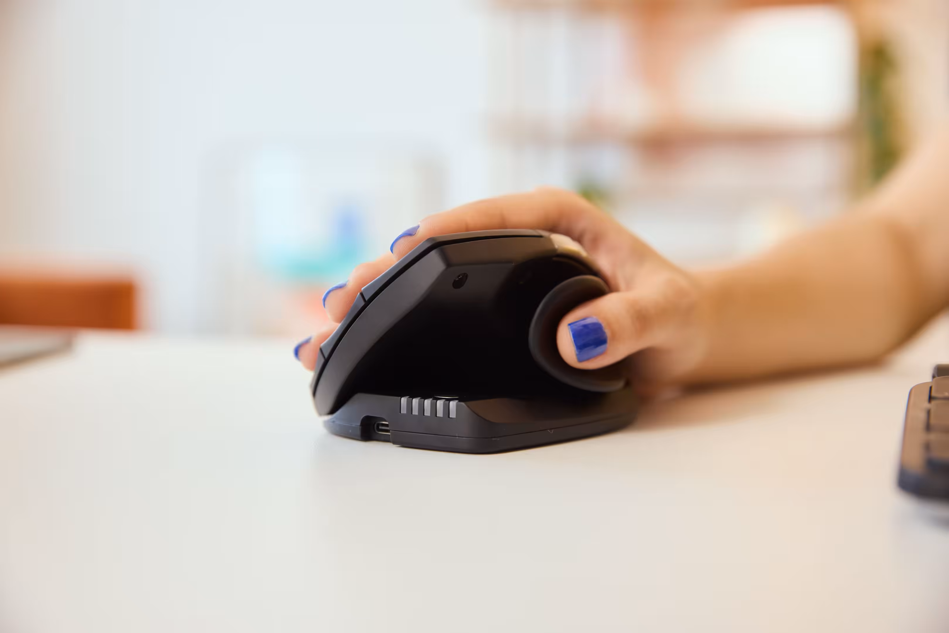 Close-up of a hand using the Contour Design Unimouse ergonomic mouse, highlighting its adjustable angle and customizable thumb rest for personalized comfort.