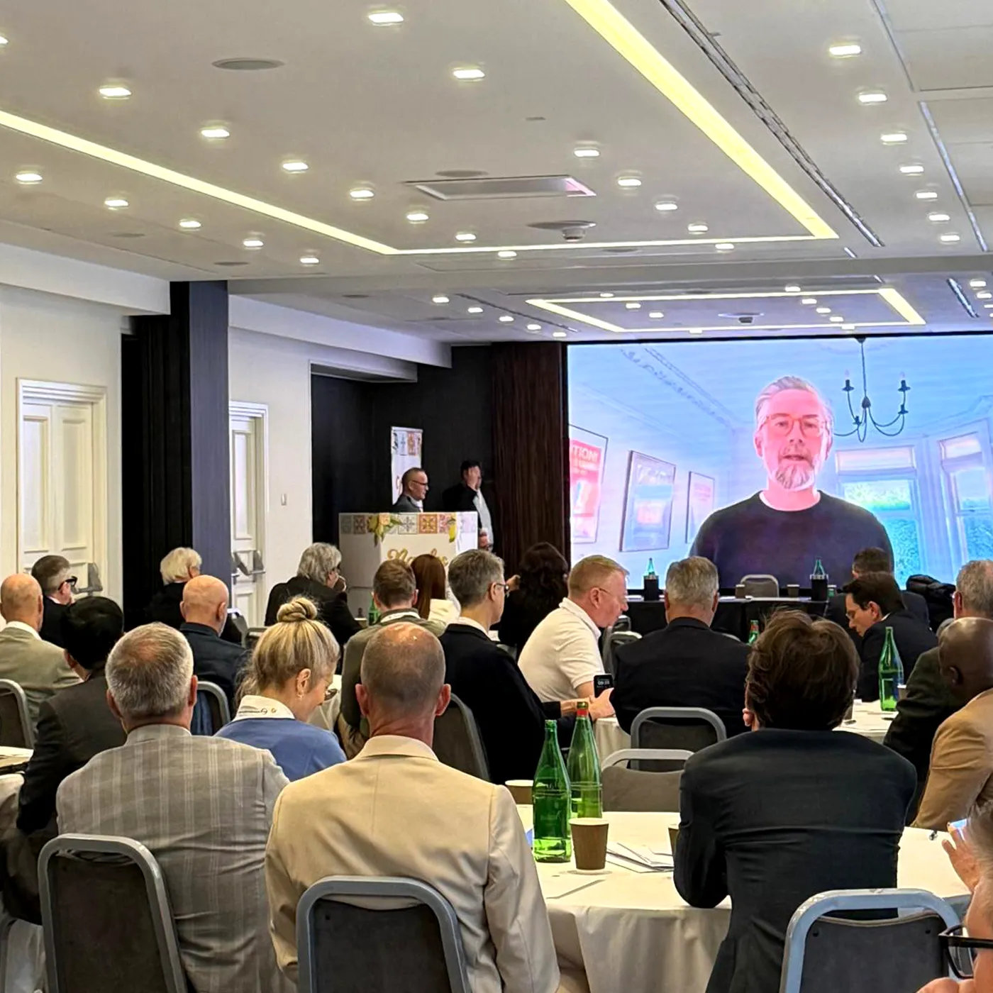 Simon Spence presenting IPG's new branding via video at a conference in Naples