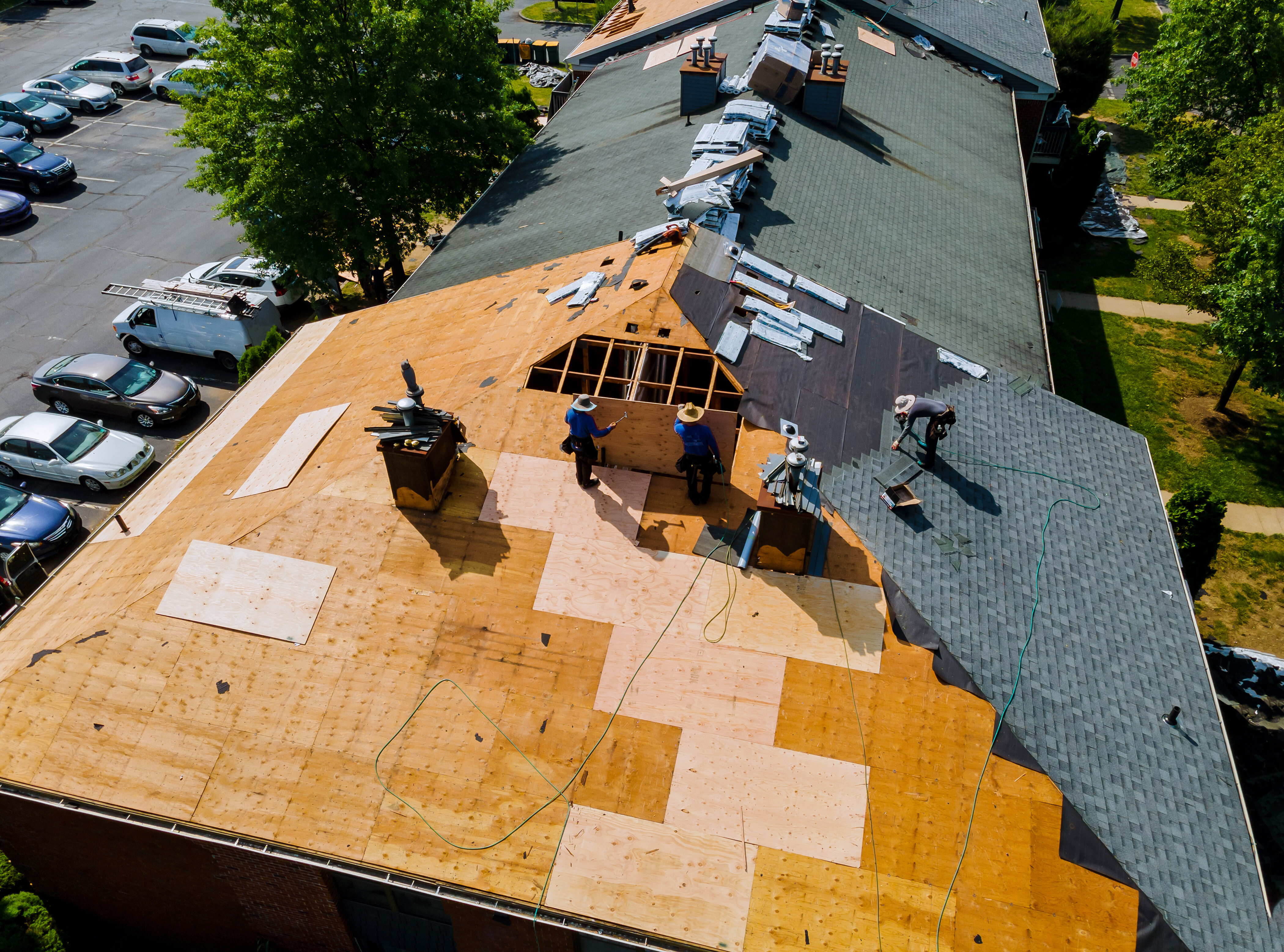 Professional roofing crew performing a full roof replacement on a Milwaukee apartment complex.