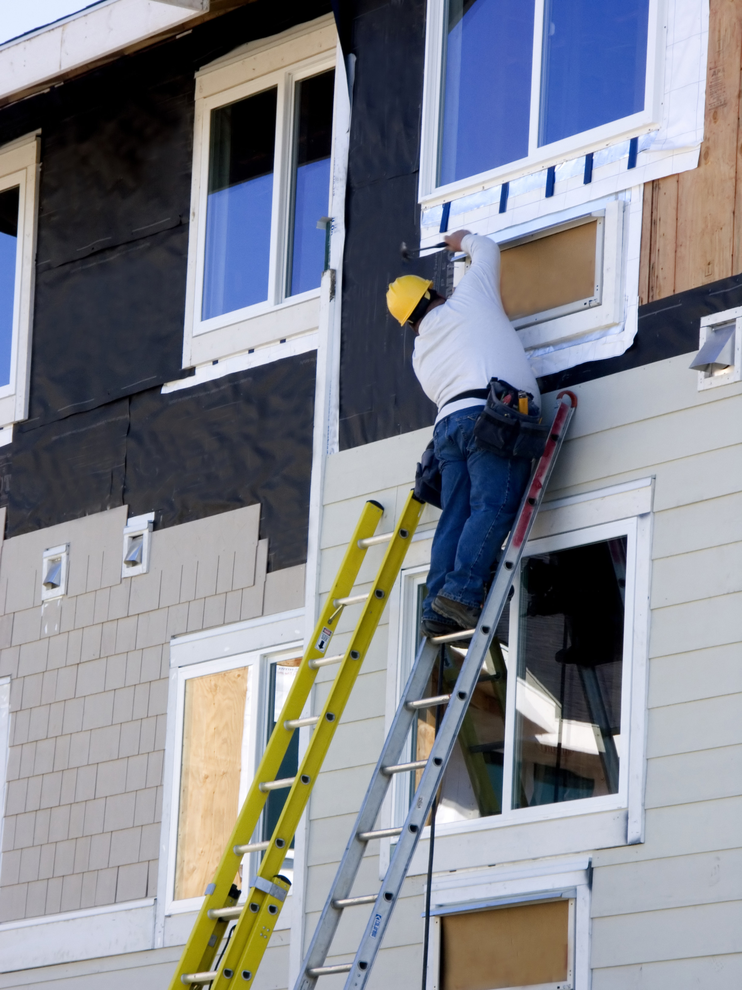 Professional siding crew precisely installing insulated siding on a residential property in the Milwaukee area.