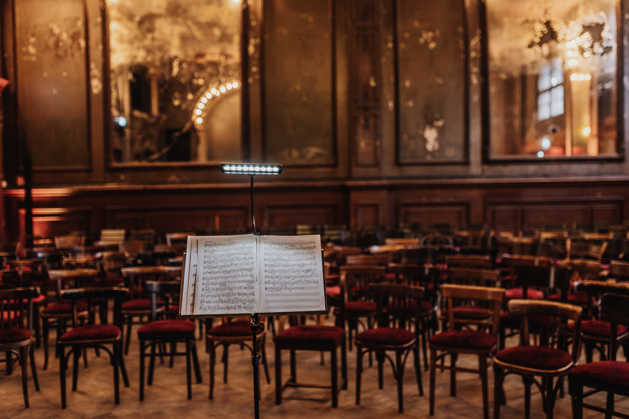 Ein Notenständer im Spiegelsaal von Clärchens Ballhaus, mit Blick auf die Bestuhlung und große, alte Spiegel.