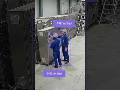 Two workers in blue coveralls on a factory floor, each tagged PPE Verified by Maneva.