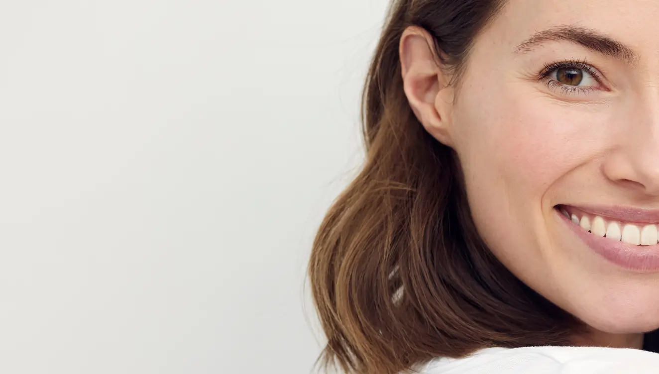 A woman with brown hair smiling and looking at the camera.