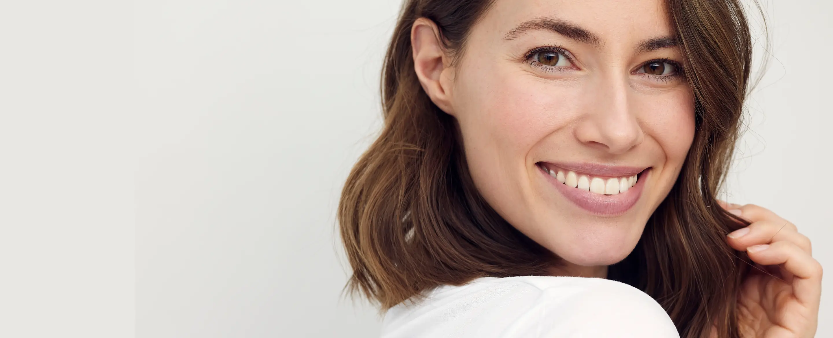 Woman smiling and looking at the camera with a cheerful expression.