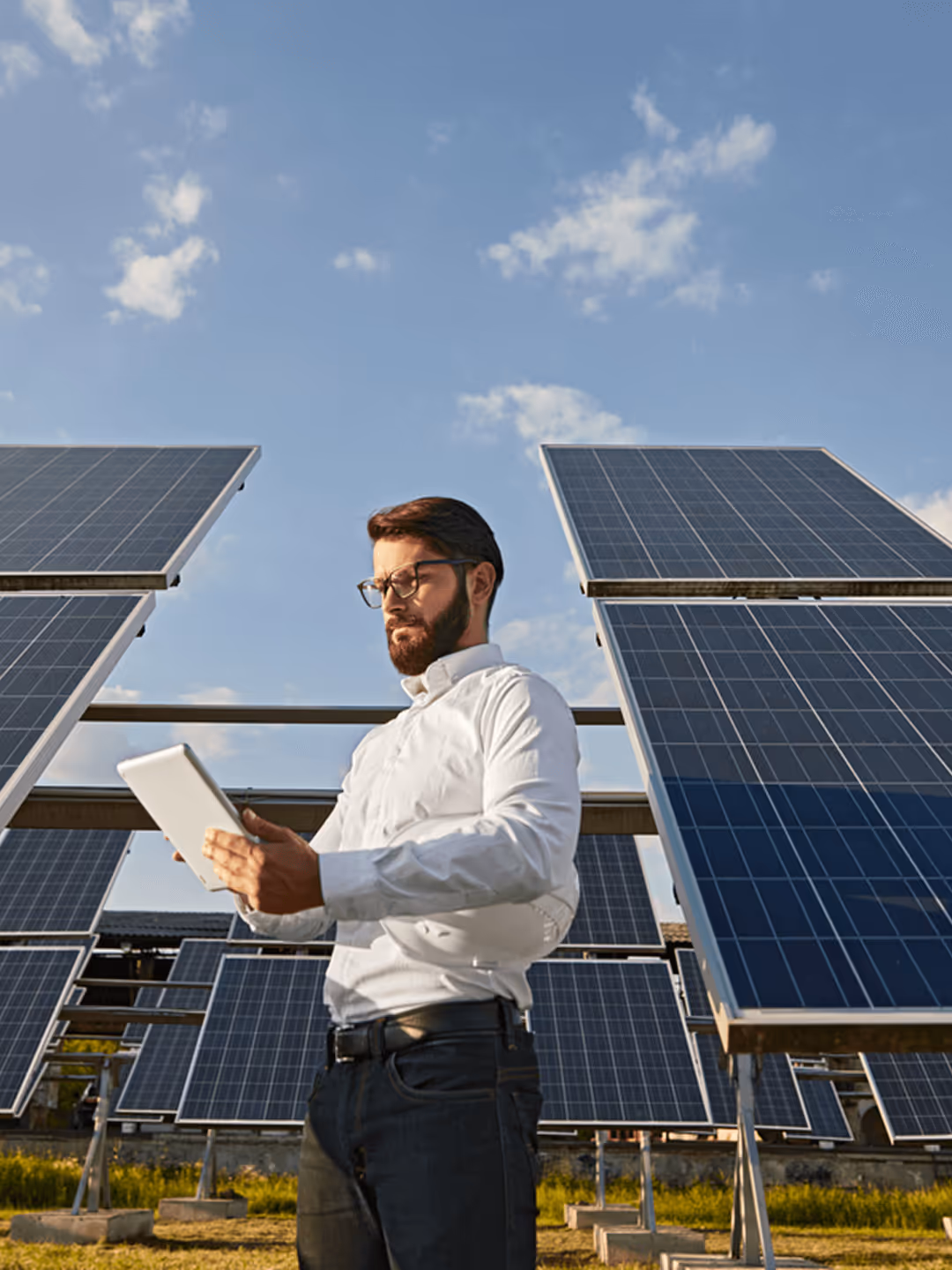 Mann mit iPad vor Solaranlage