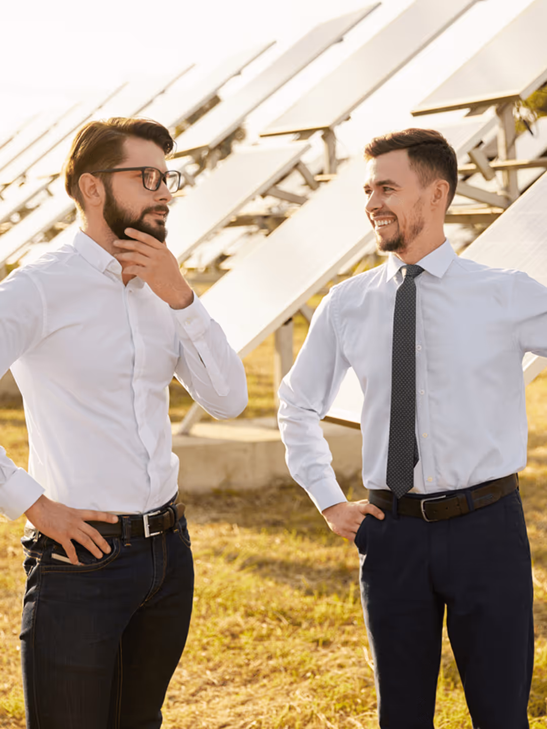 Zwei Männer gut gekleidet vor Solaranlagen besprechen sich