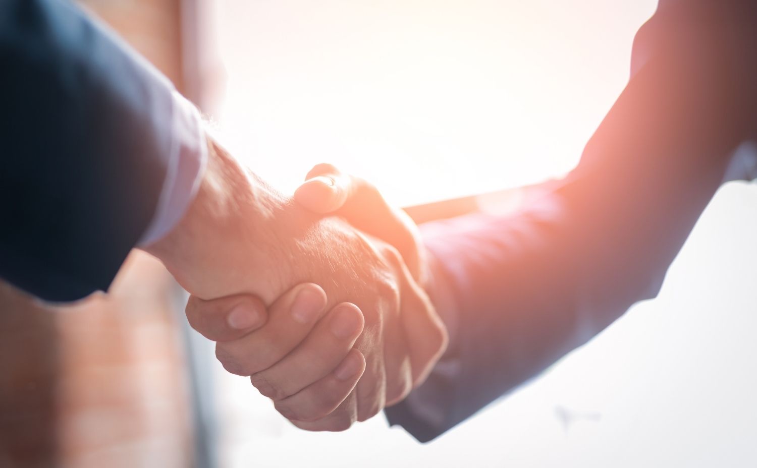 image of two people shaking hands after a deal completion