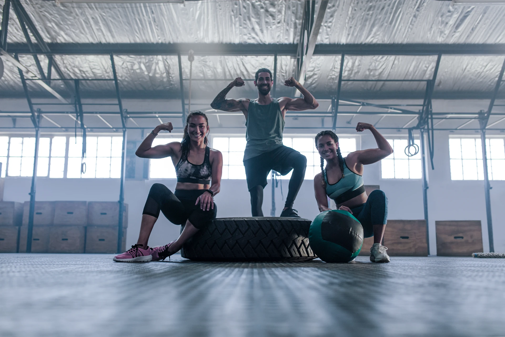 Three gym goers proudly flexing their muscles.