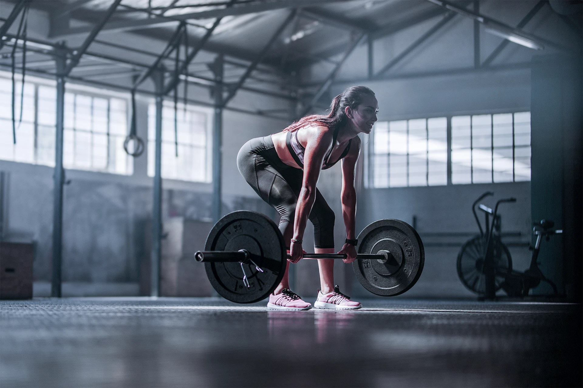 Gym goer executes a barbell Romanian deadlift using perfect form.