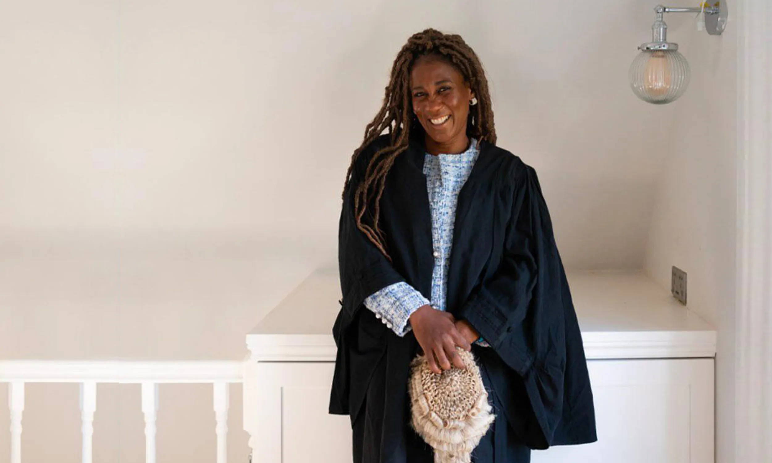 Paula Rhone-Adrien at home with her wig and gown. 