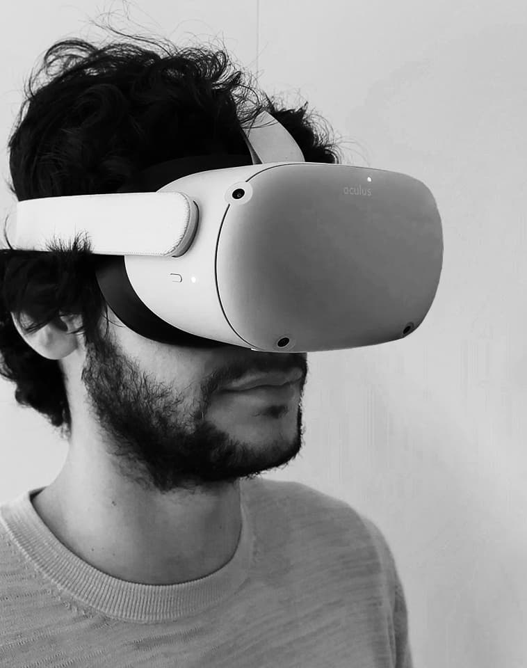 Hombre con gafas de realidad virtual Oculus mirando hacia la derecha en fondo liso.
