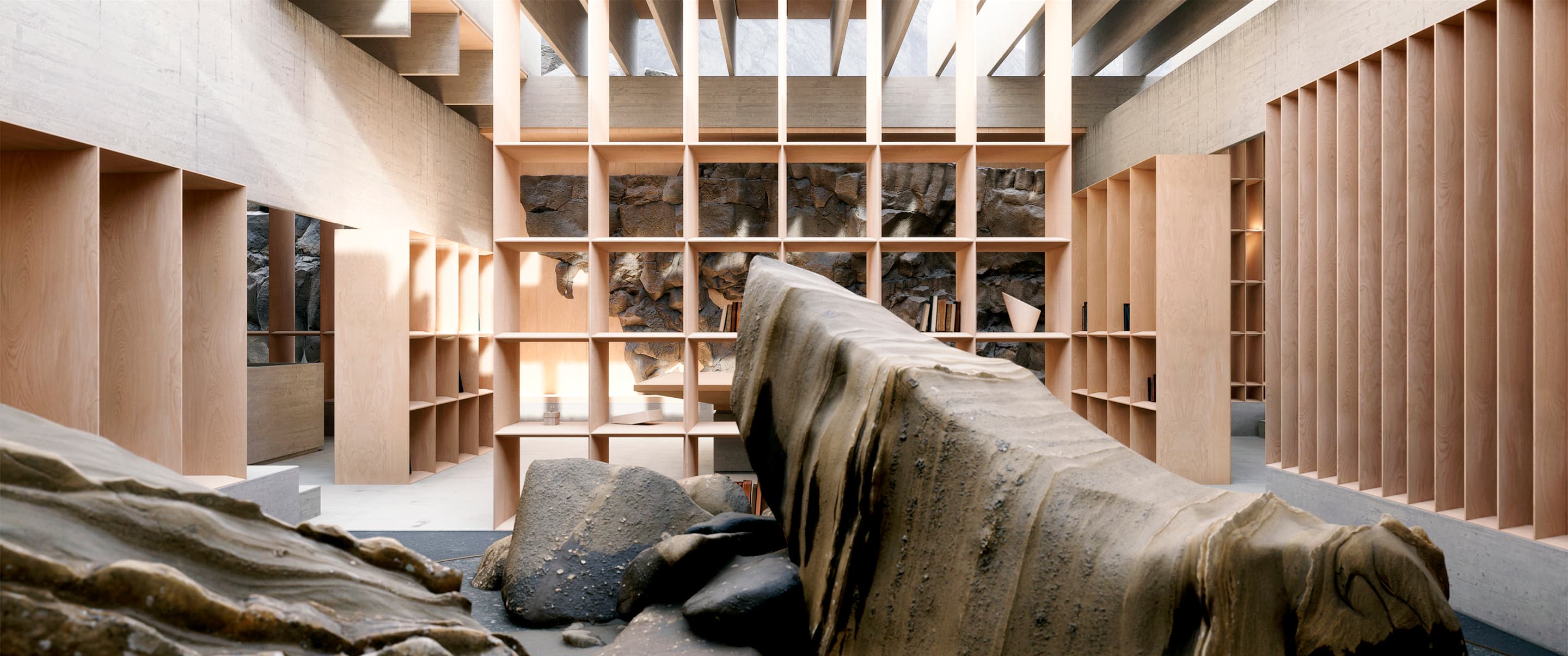 Interior con estanterías de madera y grandes rocas en el suelo frente a una pared de piedra.