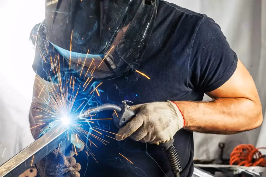 A man welder in a black t-shirt