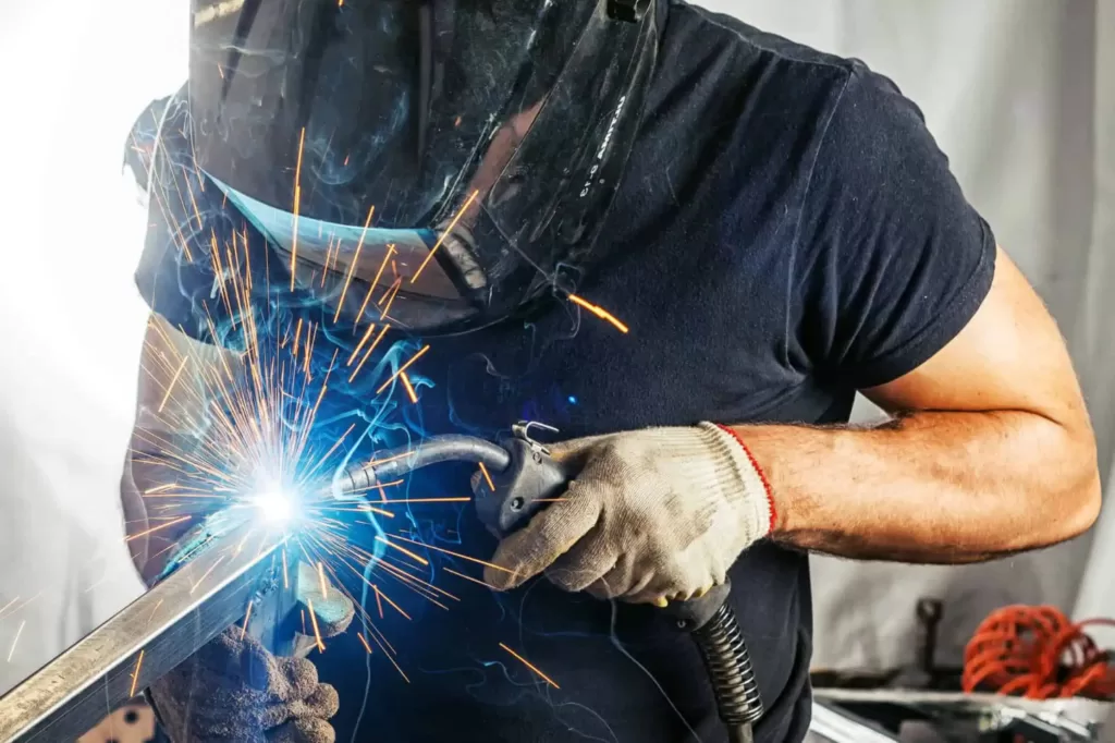A man welder in a black t-shirt