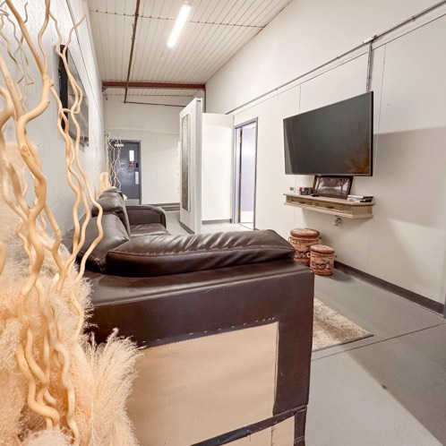 Interior lounge area with a couch and large screen tv. 