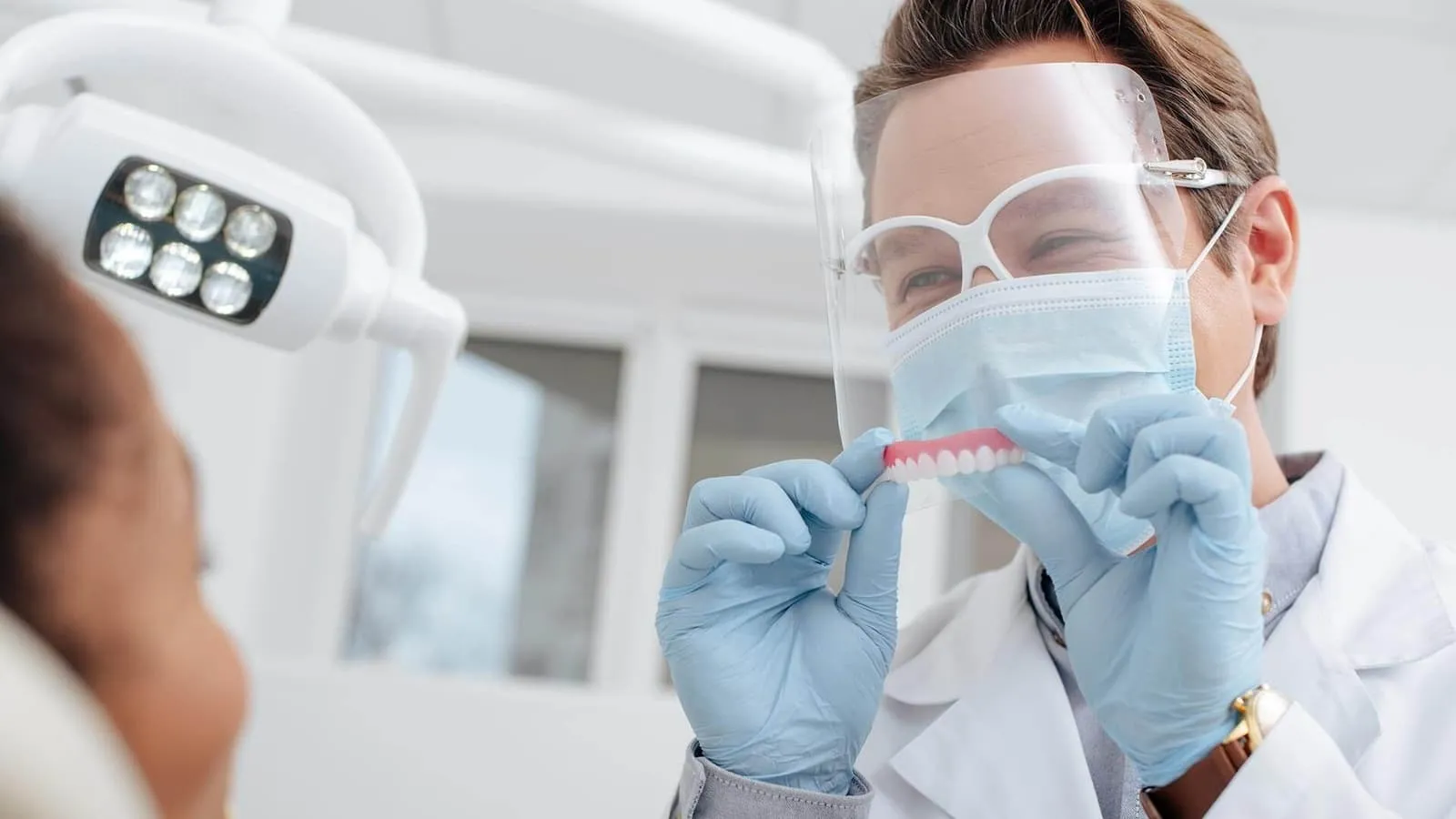 A woman in a white lab coat and goggles.