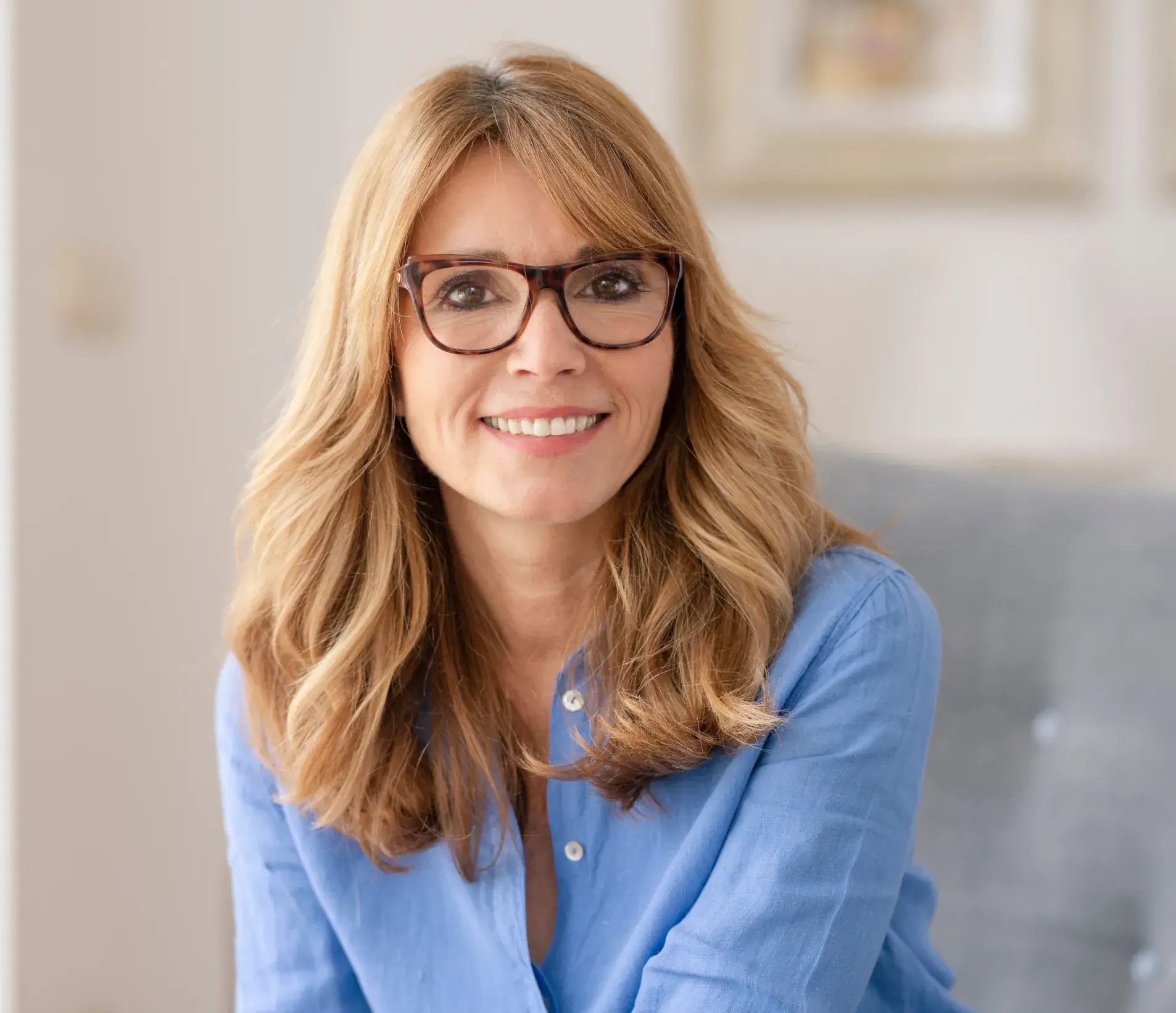 a woman wearing glasses sitting on a couch