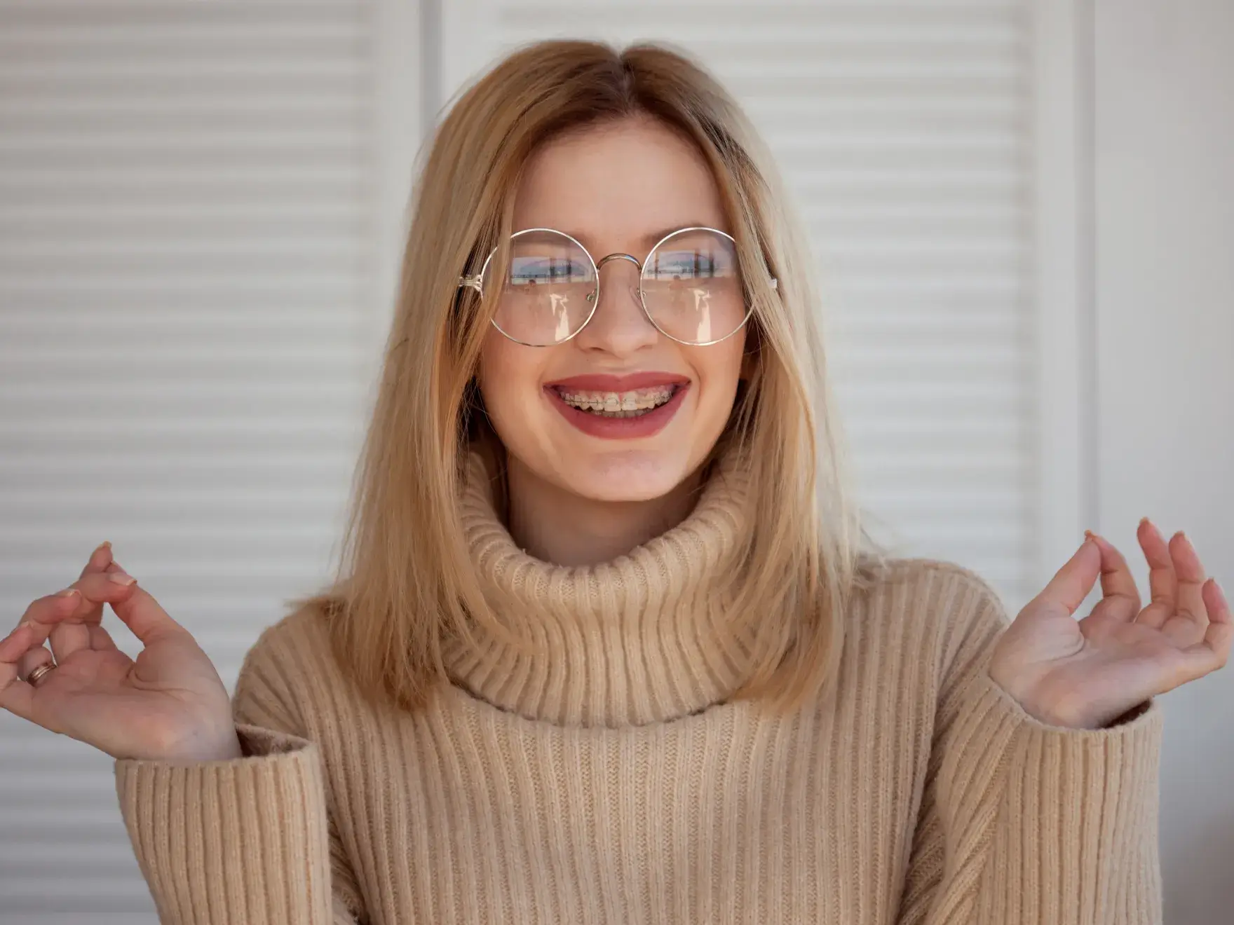 a woman wearing glasses and a turtle neck sweater