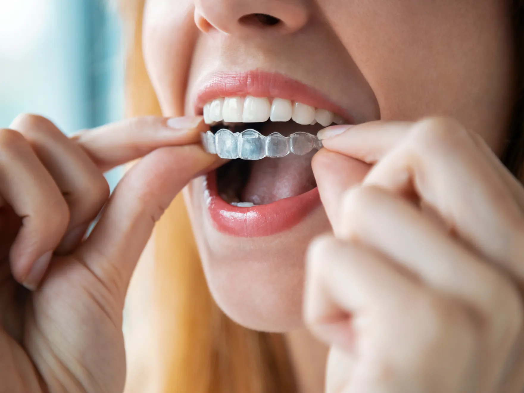 a woman brushing her teeth with a toothbrush
