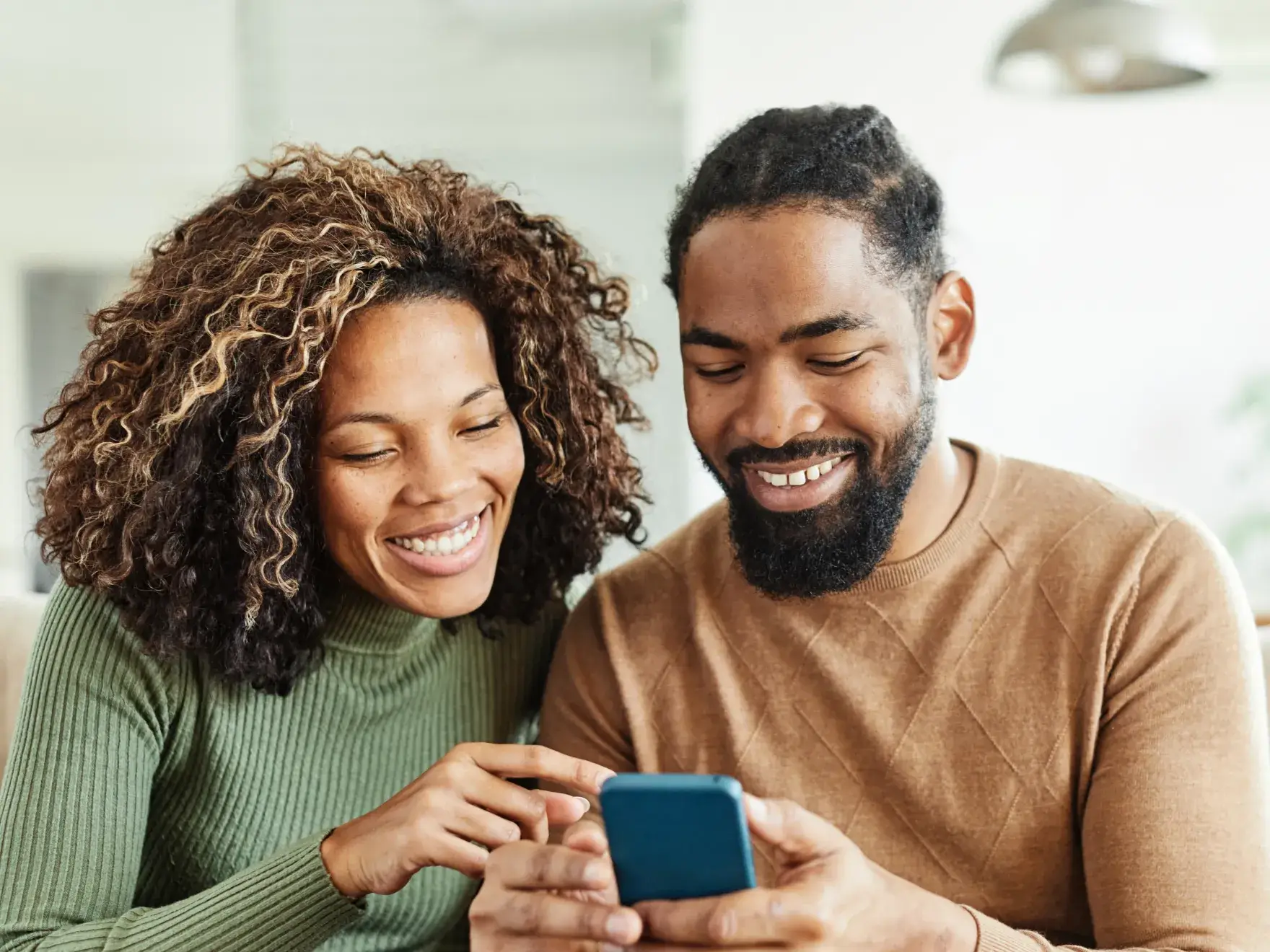 a man and woman looking at a cell phone